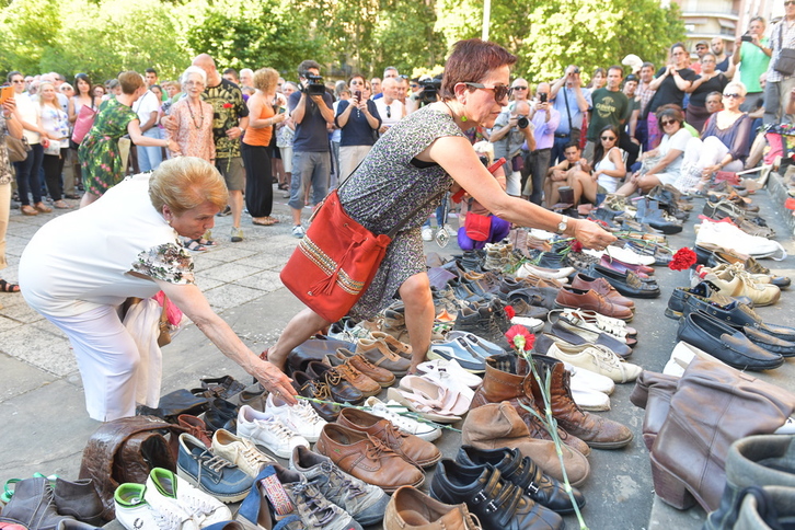 Unas mujeres depositan zapatos en memoria de los fusilados en 1936. (Idoia ZABALETA-ARGAZKI PRESS)