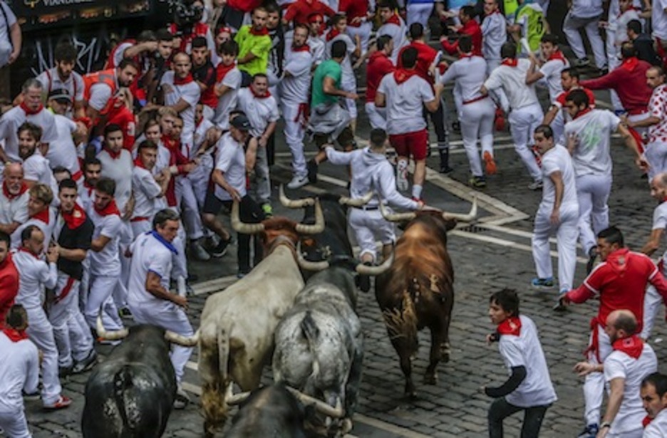 La manada enfila la plaza Consistorial con un corredor pasando apuros. (Lander FERNANDEZ DE ARROYABE/ARGAZKI PRESS)
