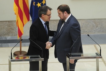 Artur Mas y Oriol Junqueras se estrechan la mano tras firmar el acuerdo. (Josep LAGO/AFP)