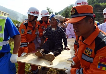Equipos de salvamento asisten a una persona herida a causa del terremoto. (Greg BAKER/AFP PHOTO)