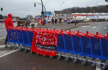 Un hombre camina junto a una barricada hecha con carros de supermercado en la localidad de Jambes. (Bruno FAHY/AFP)