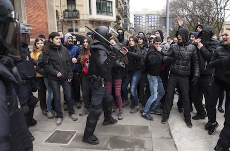 Los manifestantes en apoyo a Maravillas se acercan a un policía español. (Jagoba MANTEROLA/FOKU)