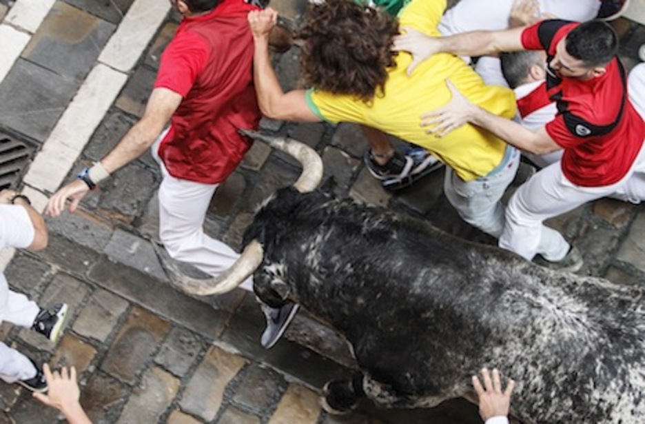 El toro Hornachuelo se abre paso entre los corredores y llega hasta el mozo de la camiseta roja. (Iñaki VERGARA/FOKU)