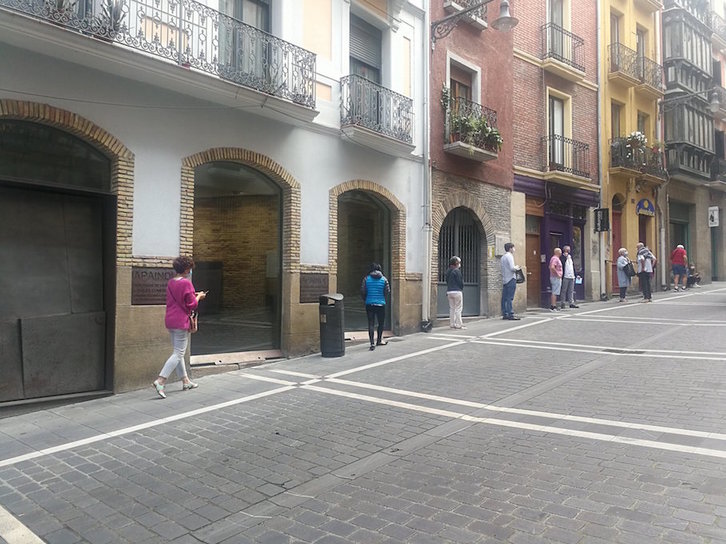 Un grupo de personas con mascarilla hace cola para acceder al comercio Pastas Beatriz en la calle Curia de Iruñea. (@MartxeloDiaz)
